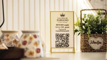 A sign with QR code for WiFi access, a basket with a heart-shaped tag, and ceramic jars.