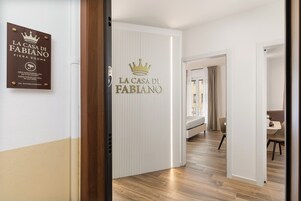 Ingresso di un hotel con una targa che recita 'La Casa Di Fabiano Fiera Rooms' e un avviso di videosorveglianza.