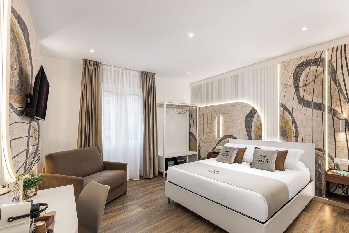 Une chambre d’hôtel moderne équipée d’un grand lit, d’un canapé, d’un bureau et d’une armoire.