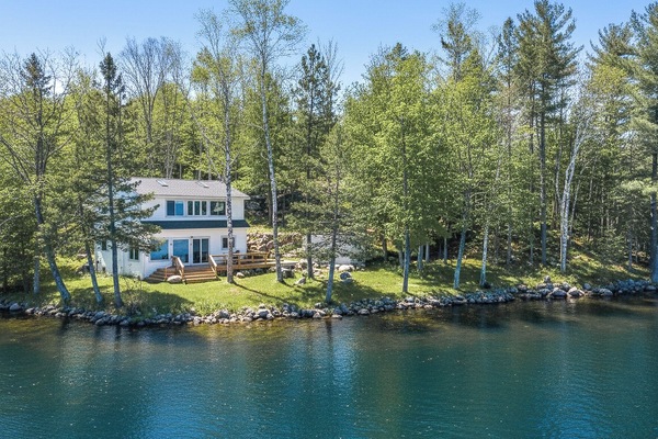 Property sits on a tree-lined lot with clear lake frontage.