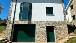Een modern herenhuis met een stenen gevel, een garage en een schotelantenne.