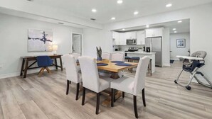 Una cocina moderna con armarios blancos, un microondas y un refrigerador.