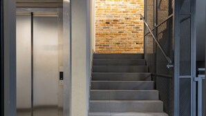 Un escalier avec une rampe en métal et un mur en briques.