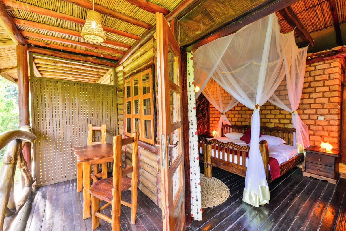 A wooden room with a bed, a table, and chairs.