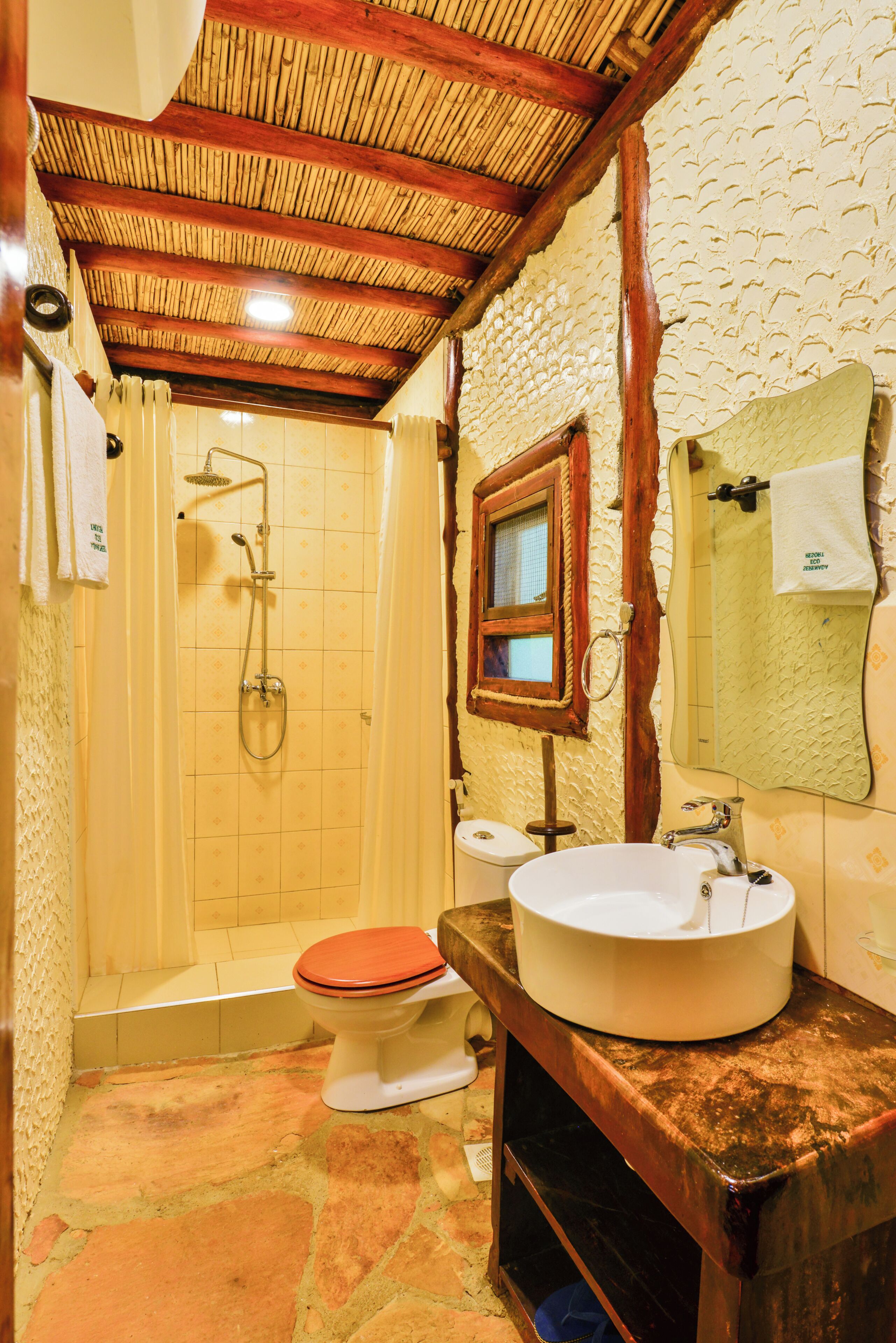 A bathroom with a shower, toilet, and sink.