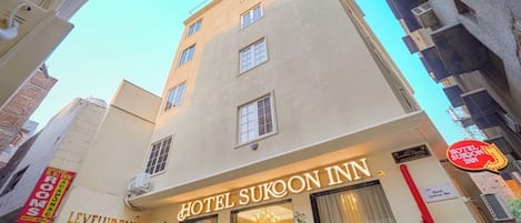 Hotel Sukoon Inn with a sign indicating it is part of the Levelup Plus Hotel Sukoon Inn complex.