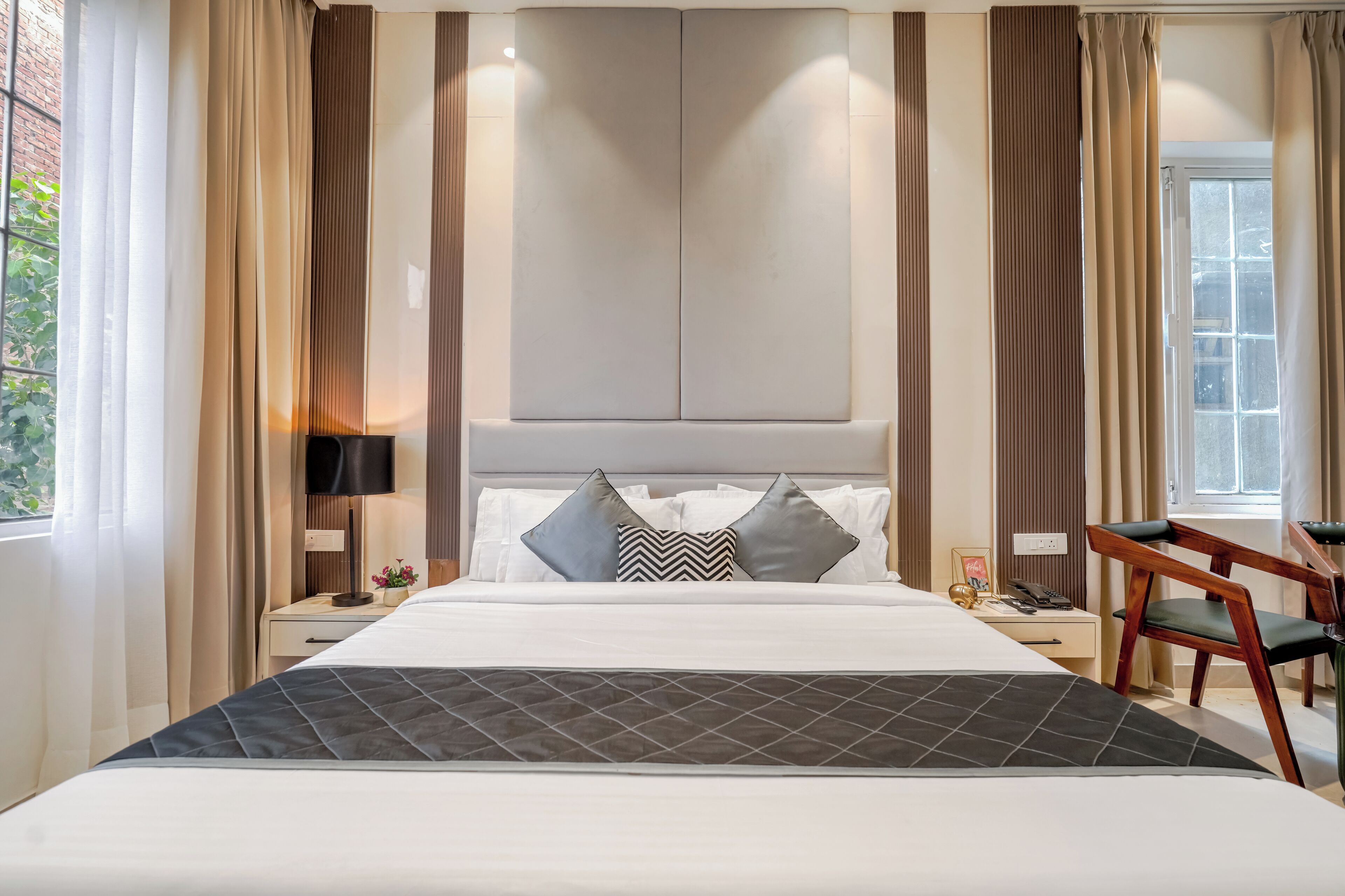 A hotel room with a large bed, a desk, and a chair.