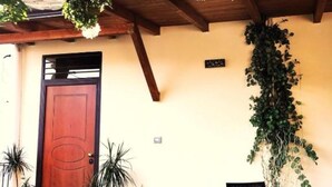A wooden door with a circular design, a wall-mounted plant, and a small sign. - Cozy Standard Double Room at B&B Miseno23, 900 m from the sea (Bacoli)