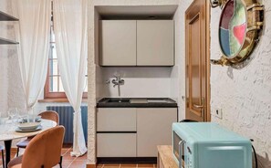 A compact kitchen with a sink, cabinets, and a vintage-style refrigerator. - In the heart of Lerici, just steps from the sea and all main amenities, Hublot awaits you — perfect for families or couples seeking relaxation and authenticity.The apartment is tastefully furnished, featuring rustic details that create a warm and welco (Lerici)