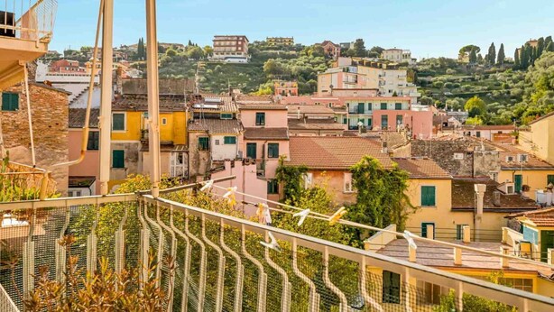 Une ville côtière aux bâtiments aux couleurs vives, avec un ciel dégagé et une vue sur la mer.