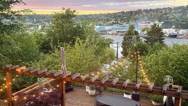 Eine Holzterrasse mit einer Pergola, Sitzgelegenheiten im Freien und Lichterketten.