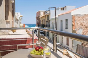 Ein Balkon mit Tisch, gedeckt mit einer Schale Trauben, einem Apfel und Gläsern mit Wasser und Zitrone.