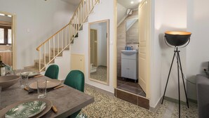 Et moderne interiør med spiseplads, trappe og badeværelse.