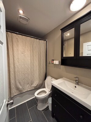 Une salle de bain avec des toilettes, un lavabo et un miroir.