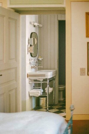 Een badkamer met een witte wastafel, spiegel en handdoekhouder.