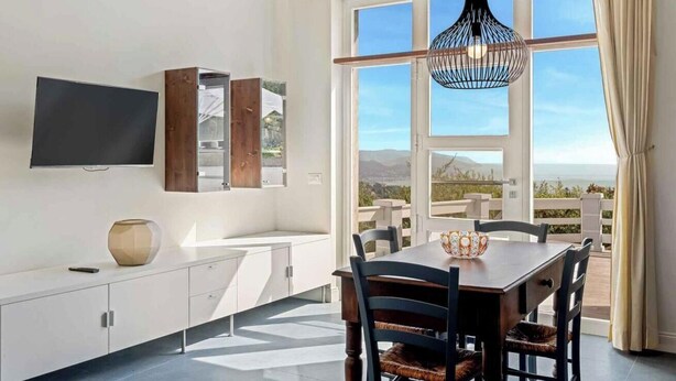 Una cocina moderna con televisor integrado, armarios de madera y un amplio ventanal con vistas panorámicas.