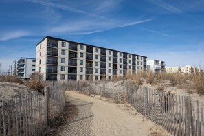 A multi-story building with a modern architectural design, featuring balconies and large windows. - Two bedroom, two bath oceanfront escape on 126th Street (Ocean City)