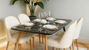 A dining area with a marble table, white chairs, and a potted plant. - Luxury Sanctuary in Covent Garden | 3 Beds, AC, Wi-Fi (London)