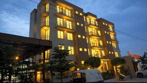 A multi-story hotel with balconies and warm lighting. - Golden Gate Hotel (Awassa)