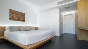 A modern bedroom with a floating bed, a wooden headboard, and a patterned wall hanging. - Hotel with swimming pool in Olbia (Olbia)