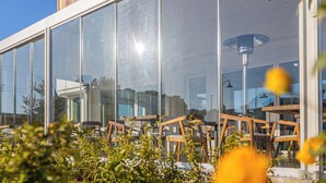 A modern building with large glass windows reflecting the sky and surrounding greenery. - Hotel with swimming pool in Olbia (Olbia)