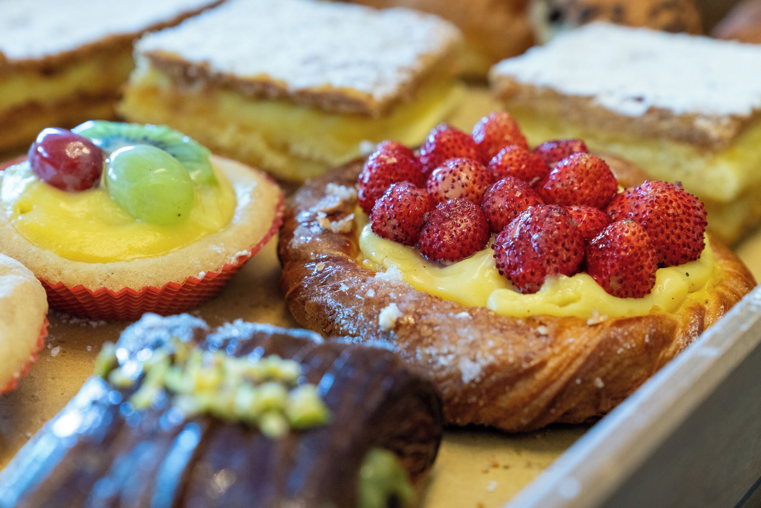 Un assortiment de desserts, notamment une tarte aux fraises et une pâtisserie à la crème.