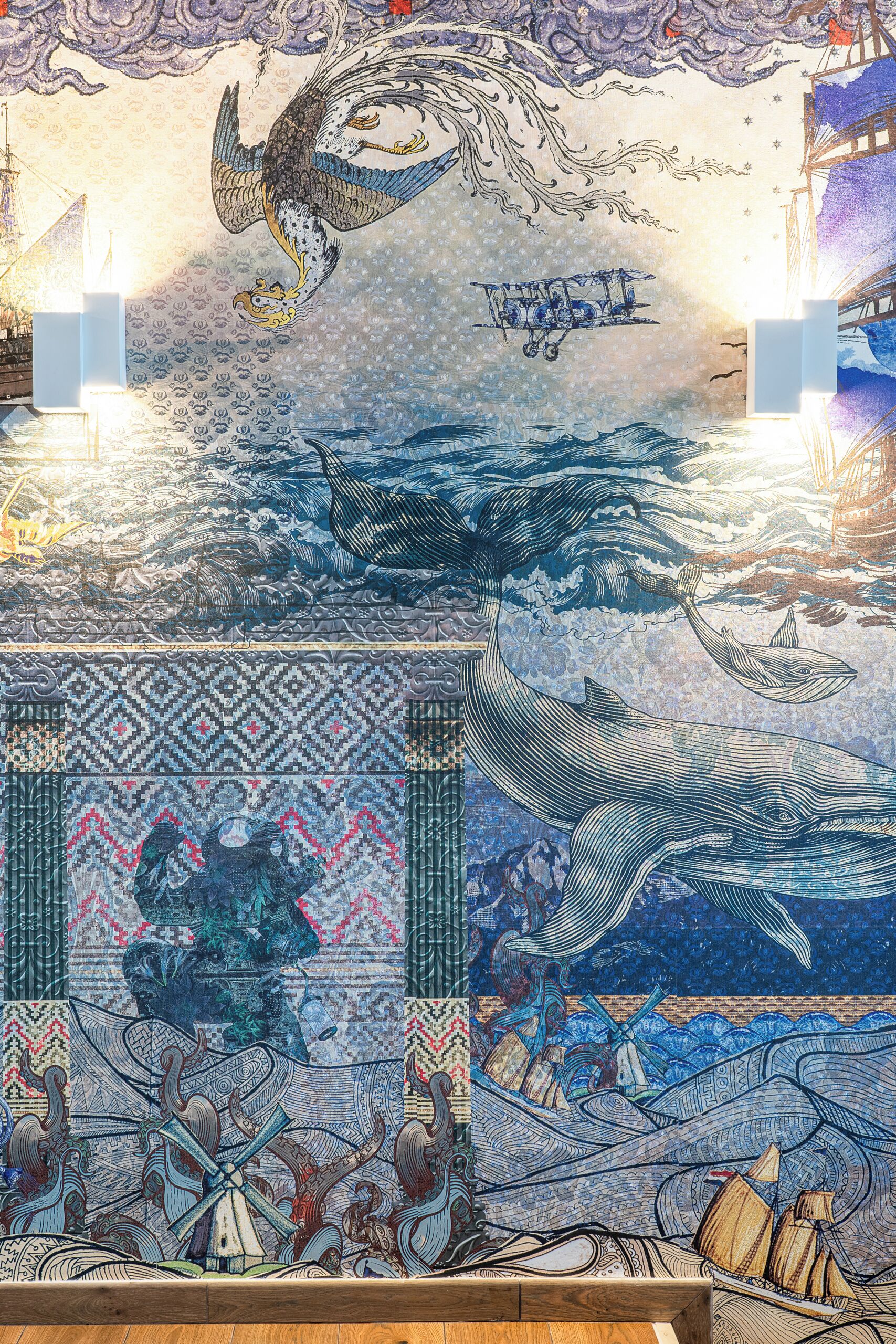 Un murale dettagliato raffigurante una nave, creature marine e motivi tradizionali.