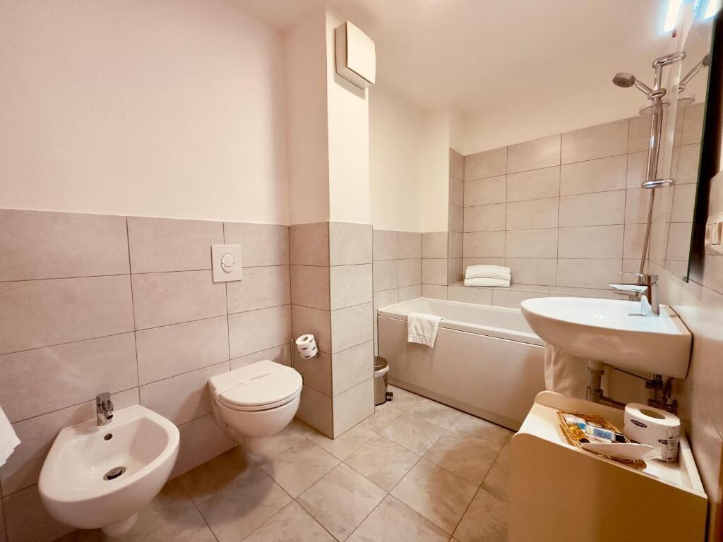 Un baño con bidé, inodoro, bañera y lavabo.