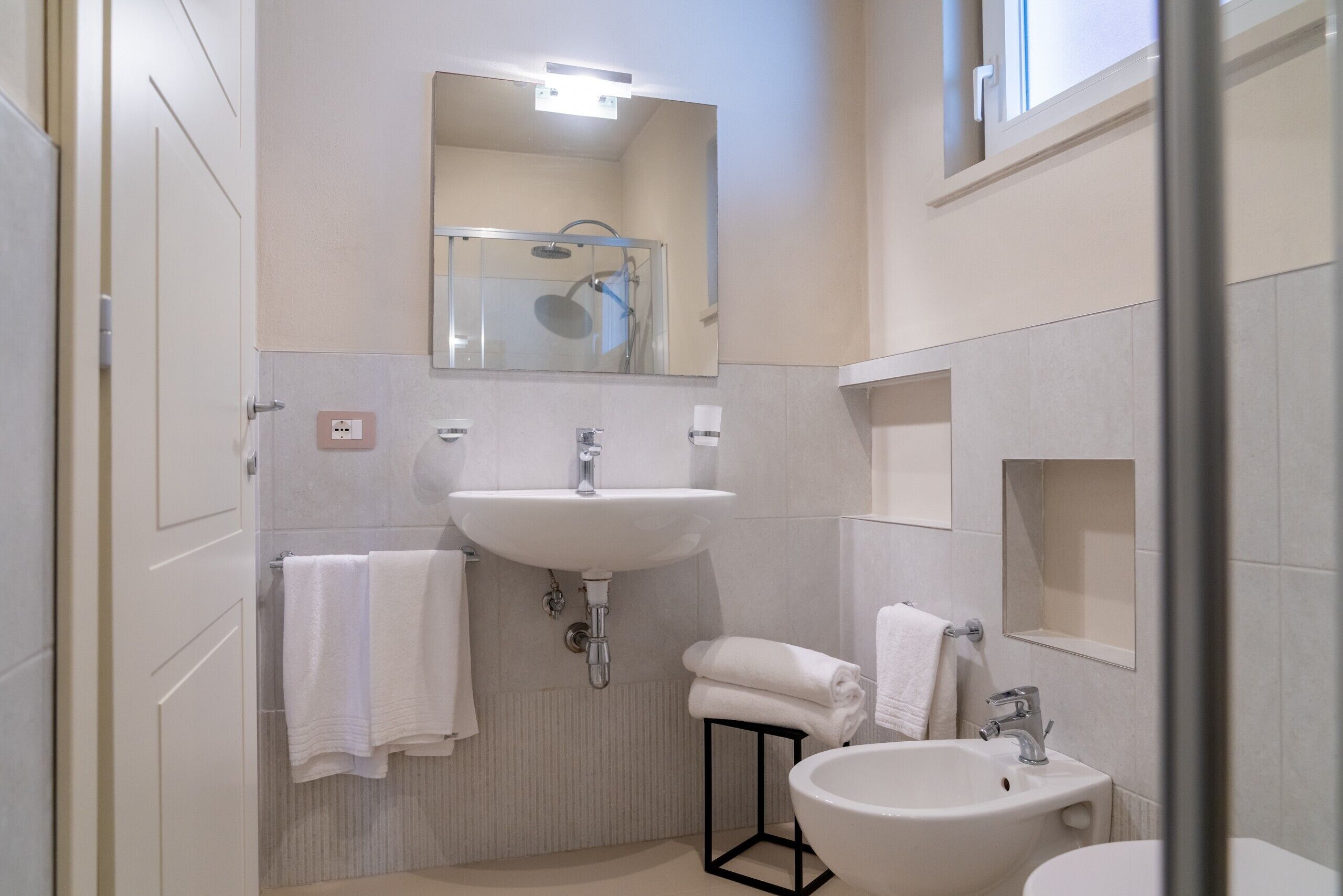 Een moderne badkamer met een grote wastafel, een spiegel en een douche.