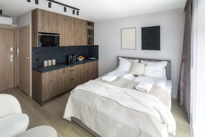 A modern hotel room with a bed, a kitchenette, and a bathroom. - Iron Street by A11 (Kraków)