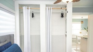 Ein Schlafzimmer mit Bett, Kleiderschrank und Deckenventilator.