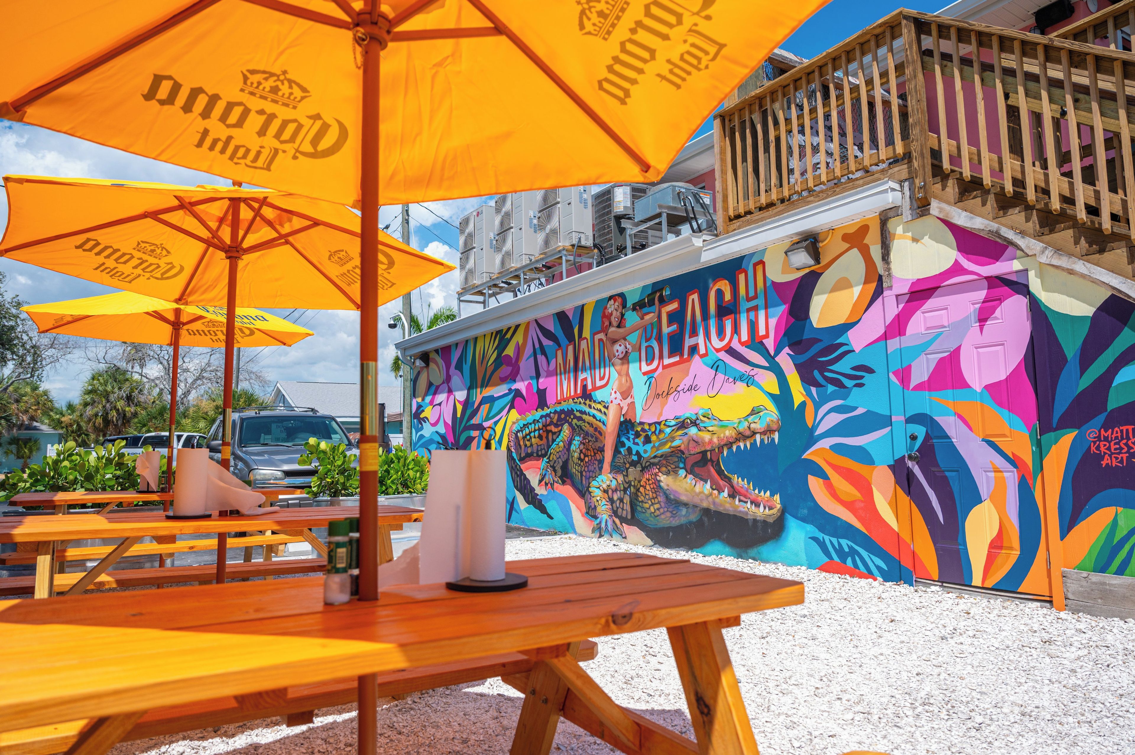 Un mural llamativo con un cocodrilo y la palabra 'MAD BEACH'.