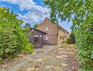 A two-story house with a gravel driveway, surrounded by greenery. - Rockford Cottage 3 Bed New Forest House & Garden (Bransgore)