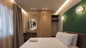 Ein Hotelzimmer mit Bett, Schreibtisch, Stuhl, Kleiderschrank und Spiegel.