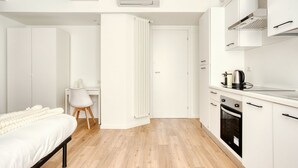 Een moderne slaapkamer met een bed, een bureau en een radiator.