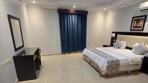 A modern hotel room with a large bed, a desk, and a window with curtains. - Makarem Najd 5 - Al Aqiq (Riyadh)