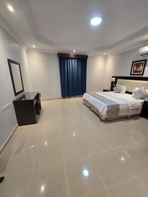 A modern hotel room with a large bed, a desk, and a window with curtains. - Makarem Najd 5 - Al Aqiq (Riyadh)