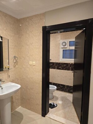 Une salle de bain équipée d’un lavabo, de toilettes et d’une douche.