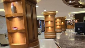 A reception area with wooden reception desks, a marble counter, and a sign indicating the reception area. - Makarem Najd 5 - Al Aqiq (Riyadh)