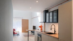 Een moderne keuken met een houten aanrecht, een ingebouwde oven en een zwarte kraan.