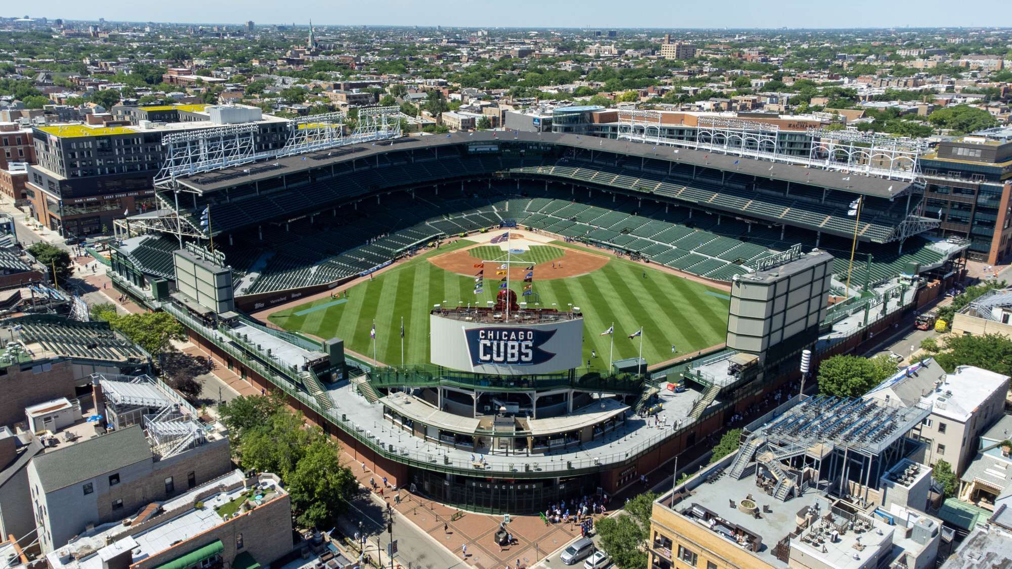 A large stadium with a prominent "Chicago Cubs" sign, surrounded by urban buildings.