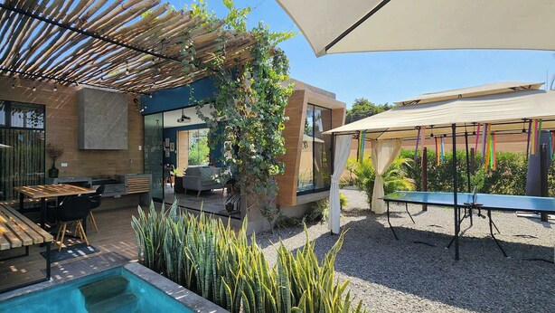 Une terrasse extérieure moderne avec une piscine, des murs en pierre et une pergola.