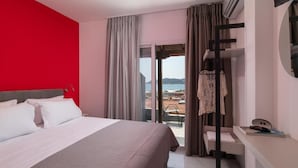 Una habitación de hotel con cama, escritorio y vista al mar.