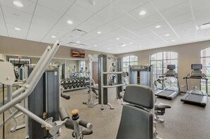 A gym with various exercise equipment, treadmills, and dumbbells. - Your Home Away from Home at Windsor at Westside (Kissimmee)
