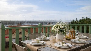 Mesa lista para comer con vista a veleros a lo lejos.