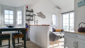 Una cocina moderna con una isla central, suelo de madera y vistas a la ciudad.
