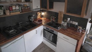 A modern kitchen with a black countertop, white cabinets, and a built-in oven. - 1 Bed Apartment - Sleeps 3 - Central London (London)