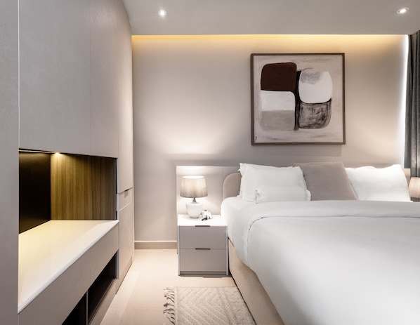 Ein modernes Schlafzimmer mit Bett, Nachttisch, Lampe und abstrakter Wandkunst.