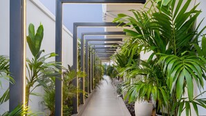 Een moderne gang met geometrische verlichting en potplanten.
