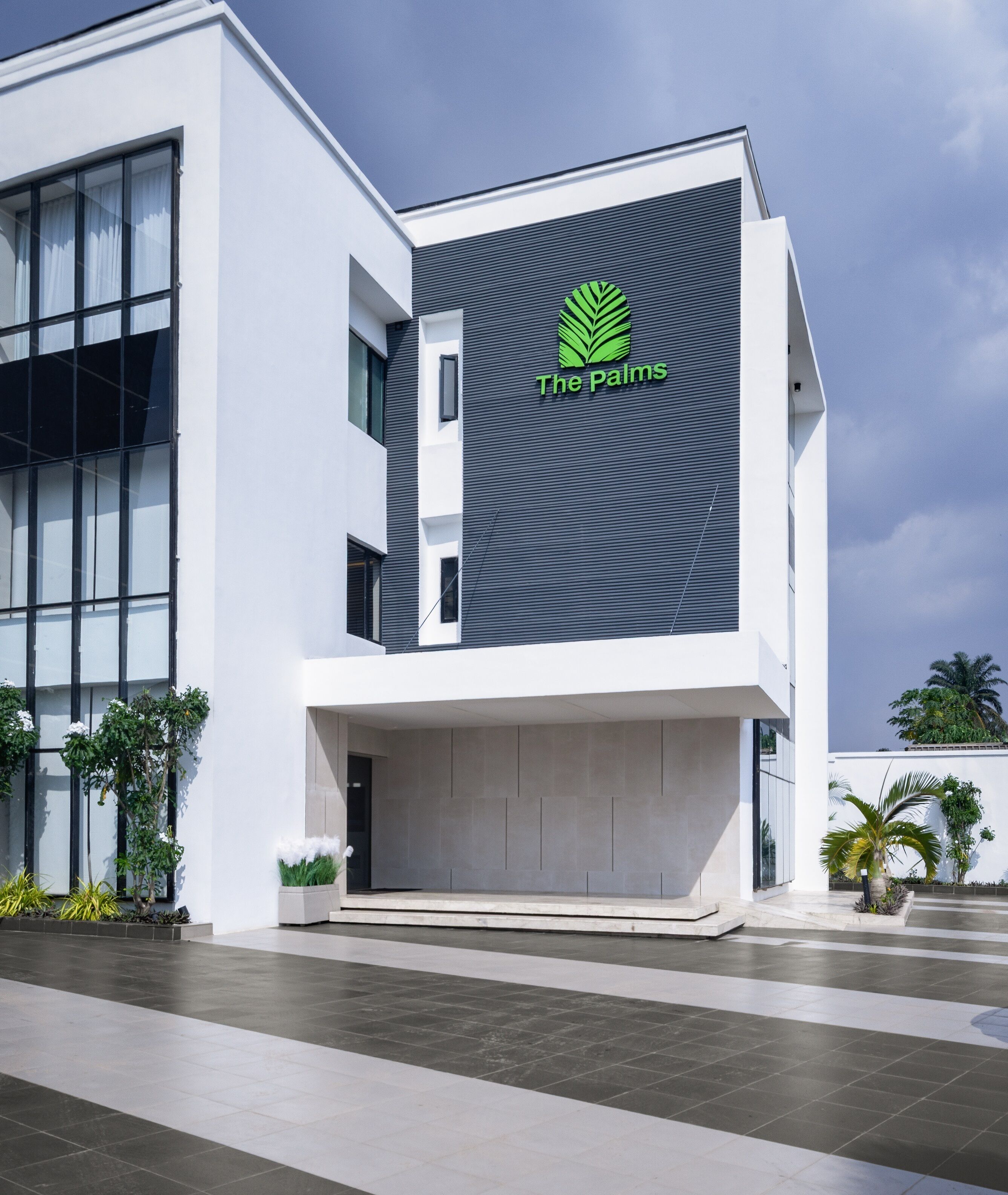 A modern building with a large glass facade, a prominent logo on the side, and a flat roof.